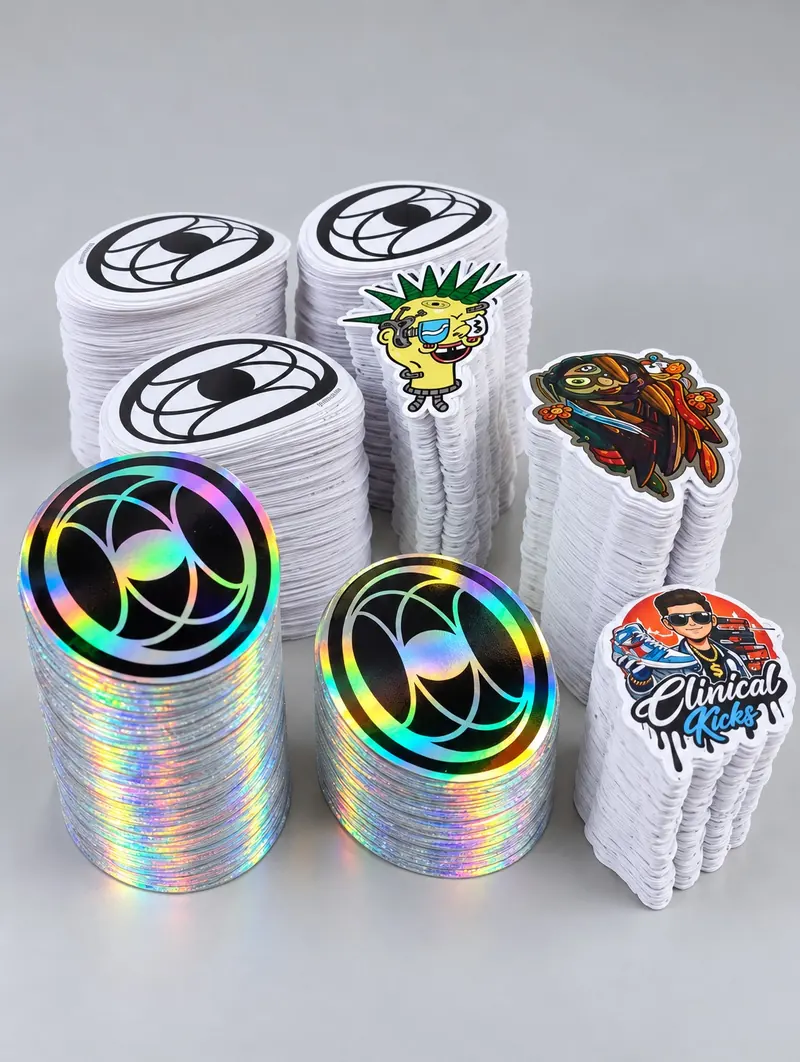 Stickers individuales apilados con diseños de colores y acabado holográfico